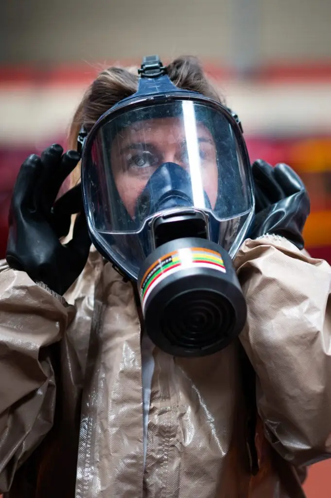 Une femme pompier ajuste son masque de protection en caserne, par Vincent Delesvaux, photographe et vidéaste à Lyon.