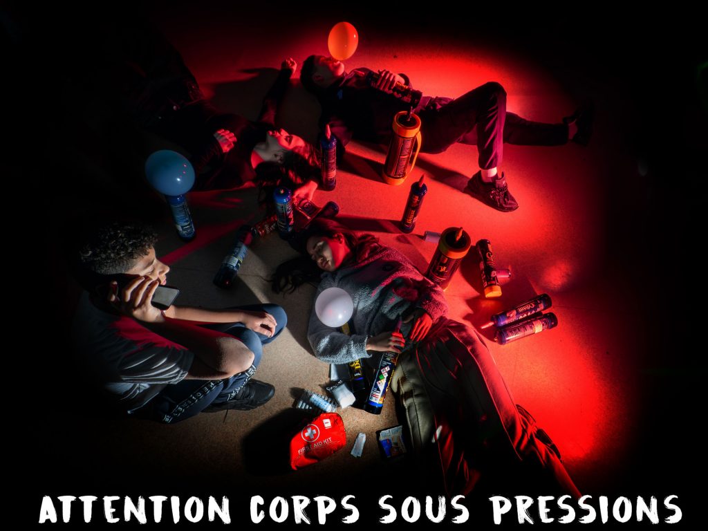 Vue de dessus d'une simulation d'overdose au gaz hilarant avec des jeunes au sol et une trousse de secours, Vincent Delesvaux, photographe vidéaste